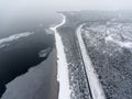 Aerial view at the Finland gulf with the Baltic sea, asphalt road passing along seaside. Winter season with snowy trees and sandy Royalty Free Stock Photo