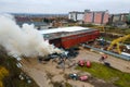 Aerial view of firemen fighting with fire near old factory biulding in industrial area