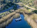 Aerial view of fishers and their fishing rods trying to catch fish on a small motor boat