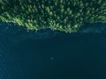 Aerial view fishing boat in blue lake and green woods in Finland