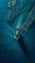 Aerial view of a fishing boat on tranquil waters, casting a reflective wake under the golden sunrise, creating a serene Royalty Free Stock Photo