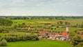 Flemish countryside with fields with trees, old houses and a windmill