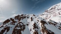 Aerial view flight climbing mountain summit cliff snow reversal dive from top ridge alpine landscape