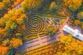 Aerial view flight over autumn valley park with trees, walking paths among the bushes of mazes