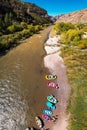 Aerial view of a flotilla of colorful rafts on Colorado River bank in Marble Canyon, Arizona