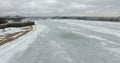 Aerial view. Flying along the river Neva in winter overcast cold weather. Bridge over the river Petersburg at dusk. The height of