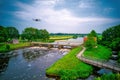 An aerial view with a flying drone in the background above a weir in the river Vecht. Lock keepers house next to the Royalty Free Stock Photo