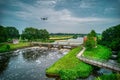 An aerial view with a flying drone in the background above a weir in the river Vecht. Lock keepers house next to the bridge. Fish Royalty Free Stock Photo