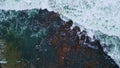 Aerial view foamy sea waves crashing huge stones. Stormy ocean washing mountain Royalty Free Stock Photo