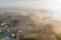 Aerial view of foggy autumn field and forest landscape. View of a small village in the morning, drone Royalty Free Stock Photo