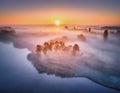 Aerial view of foggy forest at colorful sunrise in autumn