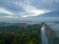 Aerial view of foggy trees in field at colorful sunrise in autumn. Colorful landscape with forest in low clouds, river Royalty Free Stock Photo