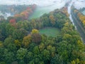 Aerial view of foggy trees in field at colorful sunrise in autumn. Colorful landscape with forest in low clouds, river Royalty Free Stock Photo