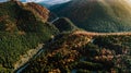 Aerial view of forest road in mountains during autumn .at sunset. Mountain empty roads details with colourful landscape Royalty Free Stock Photo