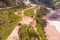 Aerial view of a four wheel drive car parked on the top of the cliff facing the Atlantic Ocean, Setubal, Portugal