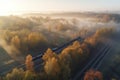 Aerial view of freight train in beautiful forest in fog at sunrise in autumn. Colorful landscape with railroad Royalty Free Stock Photo