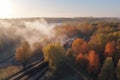 Aerial view of freight train in beautiful forest in fog at sunrise in autumn. Colorful landscape with railroad Royalty Free Stock Photo