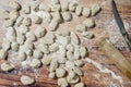 Aerial view of fresh raw gnocchi on wooden background with a small knife and manual gnocchi maker Royalty Free Stock Photo