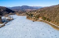 Aerial view of frozen lake Ghirla in sunny winter day, Valganna, Italy