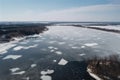 an aerial view of a frozen river with ice floes and trees in the background and a blue sky with white clouds and a few small Royalty Free Stock Photo