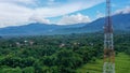 Aerial view of 4G and 5G Telecom Tower on the top of hill covered of green forest during golden hour