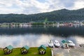 Aerial view of the gazebos in the Altai Mountains on the shore of Lake Teletskoye with three boat moored near the shore river with