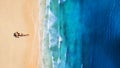 Aerial view of a girl on the beach. Beach and turquoise water. Top view from drone at beach, blue sea and relax girl.