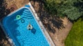 Aerial view of girl in swimming pool from above, kid swim on inflatable ring donut, fun in water on family vacation Royalty Free Stock Photo