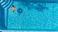 Aerial view of girl in swimming pool from above, kid swim on inflatable ring donut and has fun in water Royalty Free Stock Photo