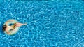 Aerial view of girl in swimming pool from above, kid swim on inflatable ring donut in water on family vacation Royalty Free Stock Photo