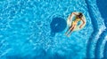 Aerial view of girl in swimming pool from above, kid swim on inflatable ring donut in water on family vacation Royalty Free Stock Photo