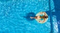 Aerial view of girl in swimming pool from above, kid swim on inflatable ring donut in water on family vacation Royalty Free Stock Photo