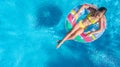 Aerial view of girl in swimming pool from above, kid swim on inflatable ring donut in water on family vacation Royalty Free Stock Photo