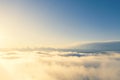 Aerial view gold sunrise over clouds in blue sky. Aerial top view cloudscape. Texture of clouds. View from above. Orange sunrise