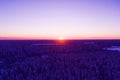 Aerial view of a gold sunset over winter snow-covered pine forest. Winter forest texture. Aerial view. Aerial drone view of a wint