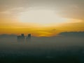 Aerial view of the golden sunrise near the neighbourhood in Malaysia with misty morning fog.