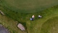 Aerial view Golf course. Golfers walking down the fairway on a course with golf bag and trolley Royalty Free Stock Photo