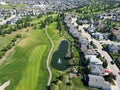 an aerial view of golf course with green grass, houses, and trees Royalty Free Stock Photo