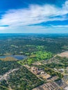 Aerial view of golf courses in a densely forested urban development