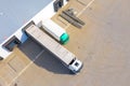 Aerial view of goods warehouse. Logistics center in industrial city zone from above. Aerial view of trucks loading at logistic