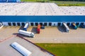 Aerial view of goods warehouse. Logistics center in industrial city zone from above. Aerial view of trucks loading at logistic