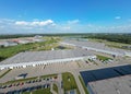 Aerial view of goods warehouse. Logistics center in industrial city zone from above. Aerial view of trucks loading at logistic