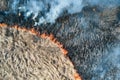 Aerial view of grassland field burning with red fire during dry season. Natural disaster and climate change concept