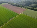 Aerial view of green crop fields and plowed agricultural field with dirt in early summer Royalty Free Stock Photo