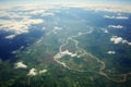 Aerial view green fields under clouds, captured from a plane window Royalty Free Stock Photo