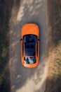 Aerial view of green forest and orange car on the road. Forest road going through forest with car adventure view from above Royalty Free Stock Photo