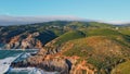 Aerial view green hills landscape stormy sea crashing rocky shoreline summer