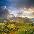 Aerial view of green meadows with villages and forest in austrian Alps mountains Royalty Free Stock Photo