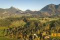 Aerial view of green meadows with villages and forest in austrian Alps mountains Royalty Free Stock Photo