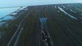 Aerial view of green piece of land with roads and swamps near the river or lake in the early spring. Shot. Picturesque